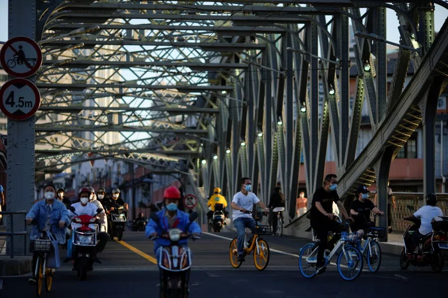 People wearing protective face masks go through a bridge, following the Covid-19 outbreak, in Shanghai, China, 19 September 2022. (Aly Song/Reuters)