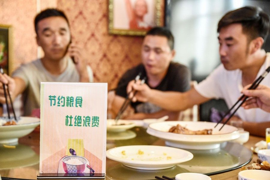 A sign encouraging people not to waste food is seen at a restaurant in Handan in China's northern Hebei province on 13 August 2020. - Chinese diners are being urged to order "one less plate", after Chinese President Xi Jinping made a speech urging the nation to stop wasting food and embrace thrift. (STR/AFP)