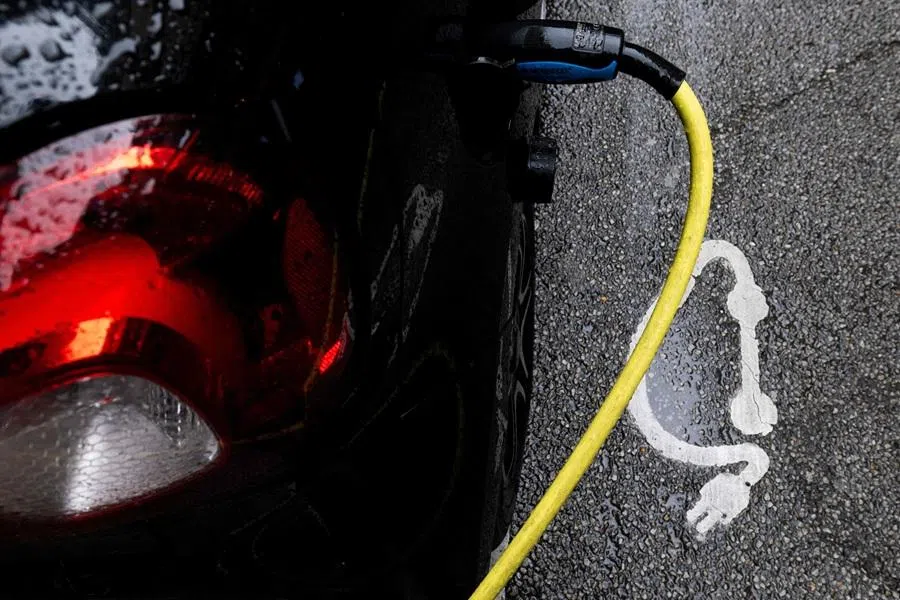 This photograph shows part of an electric vehicle plugged-in during its charging process in Paris on 13 March 2026. (Joel Saget/AFP)