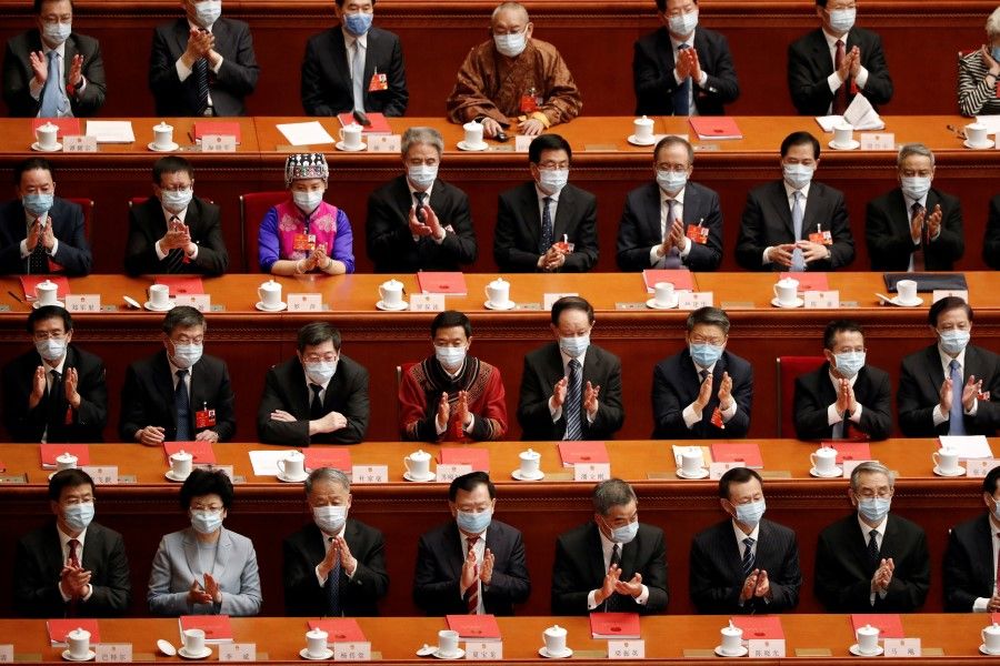 Chinese officials applaud at the closing session of the National People's Congress (NPC) at the Great Hall of the People in Beijing, 28 May 2020. (Carlos Garcia Rawlins/REUTERS)