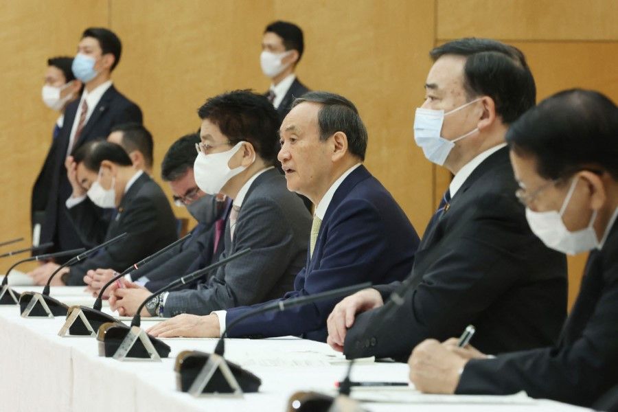 Japan's Prime Minister Yoshihide Suga (centre) speaks at a cabinet meeting at the prime minister's office in Tokyo on 13 April 2021. (STR/Jiji Press/AFP)