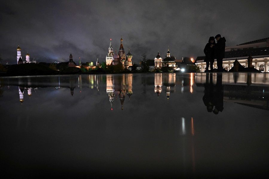 A man walks through the Zaryadye Park in downtown Moscow, with the Kremlin's Spasskaya Tower and St Basil's Catherdal in the background on 17 October 2023. (Natalia Kolesnikova/AFP)