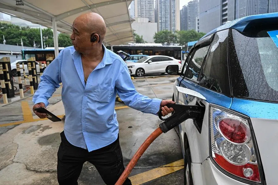 In this picture taken on 18 October 2023, a taxi driver charges his electric vehicle at Antuoshan charging station in Shenzhen, China's southern Guangdong province.