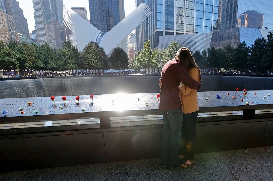 People mourn at the 9/11 Memorial on the 20th anniversary of the September 11 attacks in Manhattan, New York on 11 September 2021. (Mike Segar/Pool/AFP)