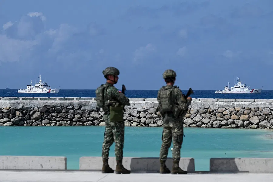 Philippine soldiers look at Philippine Coast Guard vessels near Thitu Island in the disputed South China Sea on 1 December 2023. (Jam Sta Rosa/AFP)
