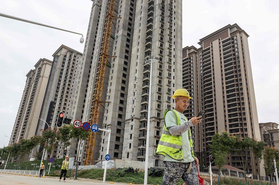 A worker walks past a housing complex under construction by Chinese property developer Evergrande in Wuhan, Hubei province, China, on 28 September 2023. (AFP)