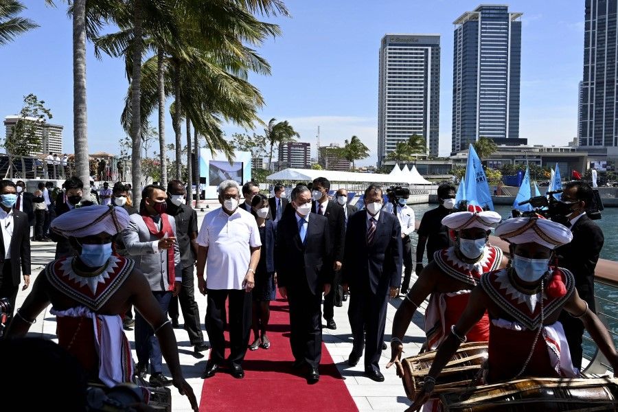 Sri Lankan President Gotabaya Rajapaksa (centre left) arrives with Chinese Foreign Minister Wang Yi (centre right) at a sailing event on the occasion of the 65th anniversary of diplomatic relations between Sri Lanka and China during his visit to Colombo Port city project, in Colombo on 9 January 2022. (Ishara S. Kodikara/AFP)