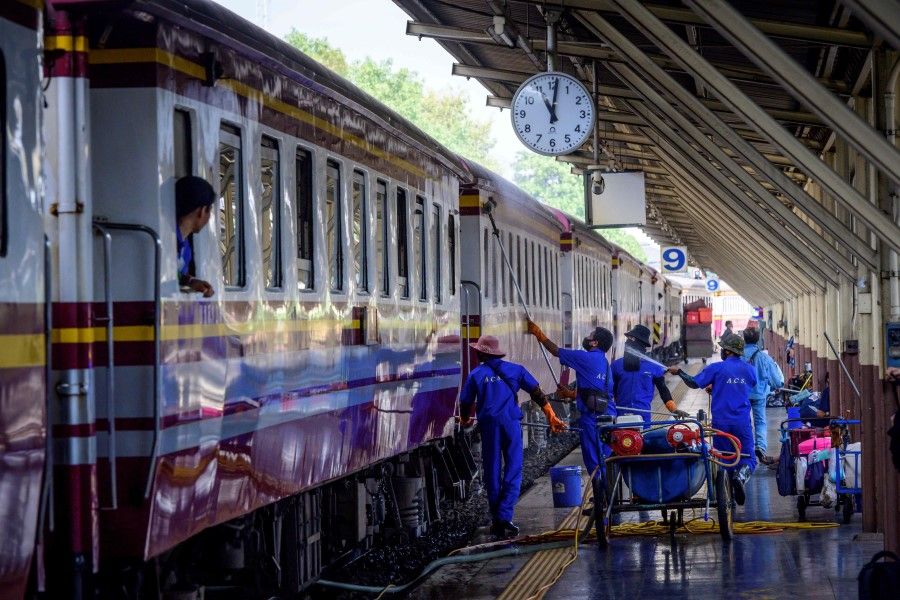 Employees clean and disinfect a train at Hua Lamphong Central Railway Station in Bangkok on 4 January 2021. (Mladen Antonov/AFP)