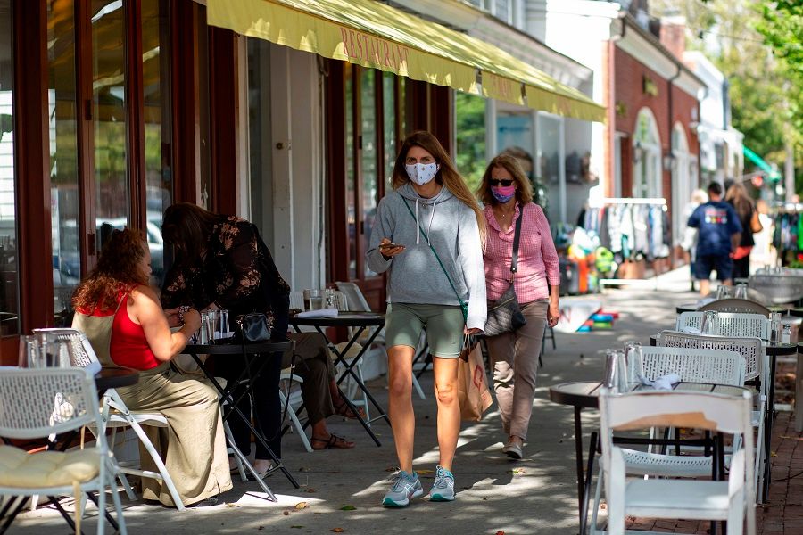 People wearing face masks walk by Main Street on 30 September 2020 in Southampton, New York. (Kena Betancur/AFP)