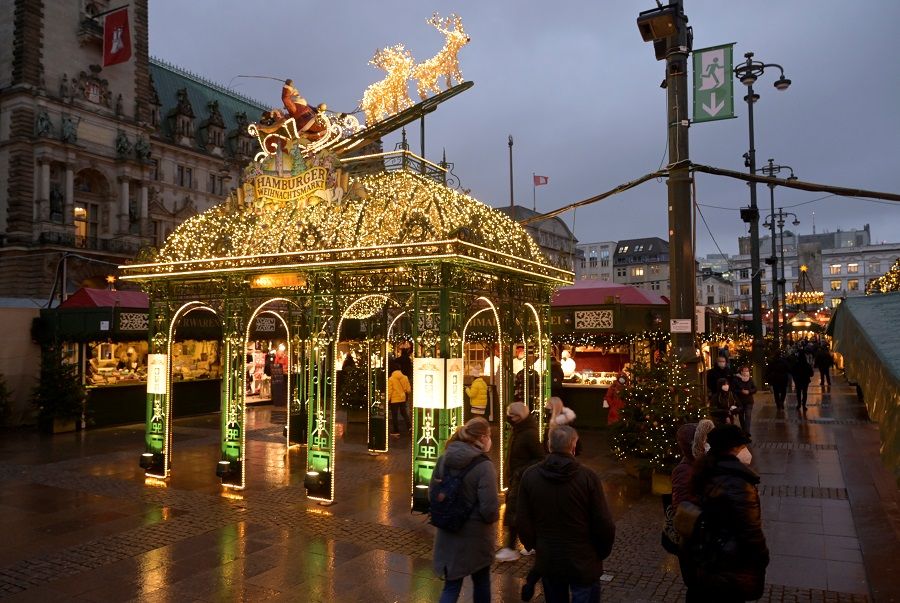 People visit a Christmas market in Hamburg, Germany, 1 December 2021. (Fabian Bimmer/Reuters)