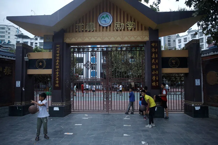 Teenagers are seen in front of a primary school in Ganluo county, Liangshan Yi Autonomous Prefecture, Sichuan province, China, 9 September 2020. Picture taken September 9, 2020. (Tingshu Wang/Reuters)