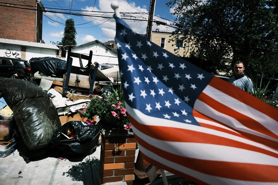 People clean up their flooded homes in a Queens neighborhood that saw massive flooding and numerous deaths following a night of heavy wind and rain from the remnants of Hurricane Ida on 3 September 2021 in New York City, US. (Spencer Platt/Getty Images/AFP)