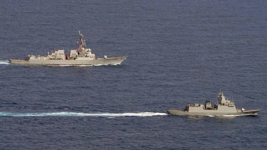 This handout photo taken and released on 4 September 2023 by the Armed Forces of the Philippines shows the US Navy's USS Ralph Johnson guided missile destroyer (left) and the Philippine Navy frigate BRP Jose Rizal sailing through waters west of Palawan in the South China Sea. (Handout/Armed Forces of the Philippines/AFP)