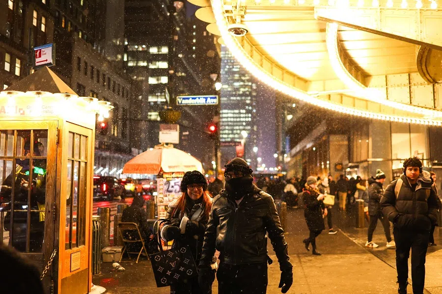Pedestrians walk as the snow falls in the Manhattan borough of New York City on 20 February 2025. (Charly Triballeau/AFP)