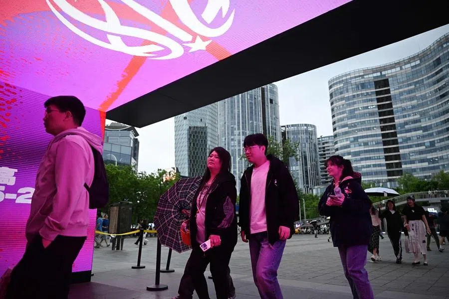 People enter a shopping mall in Beijing on 2 May 2026. (Greg Baker/AFP)