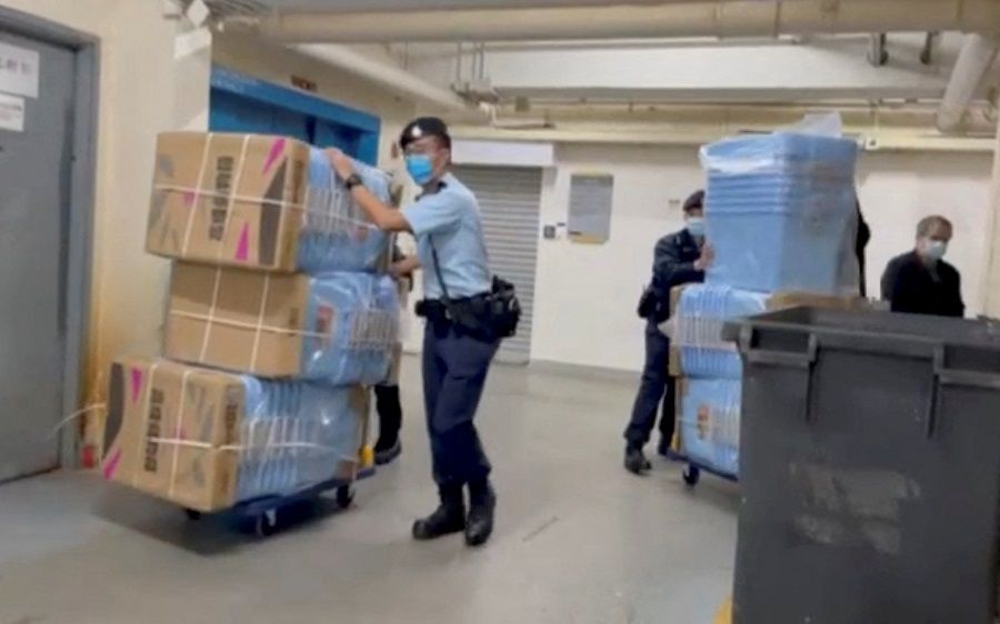 Police officers push boxes to collect evidence during their raid operation at Stand News office, in Hong Kong, China, 29 December 2021 in this still image from a video obtained by Reuters. (Reuters)