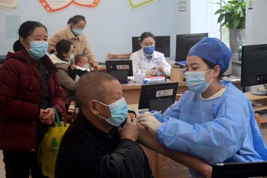 A medical worker administers a dose of the vaccine against Covid-19 to an elderly resident at a community health service centre in Jinhua, Zhejiang province, China, 5 December 2022. (China Daily via Reuters)