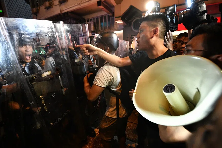 (From right) Hong Kong Legislative members Au Nok-him (holding a loud hailer) and Jeremy Tam clashing with police at Mong Kok on 7 July 2019. (SPH Media)