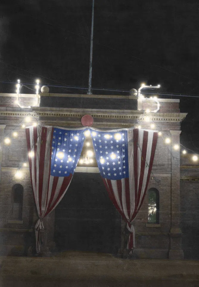 A Christmas celebration at the US embassy in Beijing, 1915. Two giant US flags are hung at the door, along with light decorations. This door still exists today, leading to a leisure facility built on the site of the embassy.