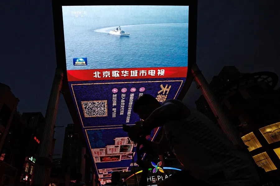 A screen broadcasts news footage of a Navy Force vessel taking part in military drills by the Eastern Theatre Command of China's People's Liberation Army around Taiwan, in a shopping area in Beijing, China, 19 August 2023. (Tingshu Wang/Reuters)