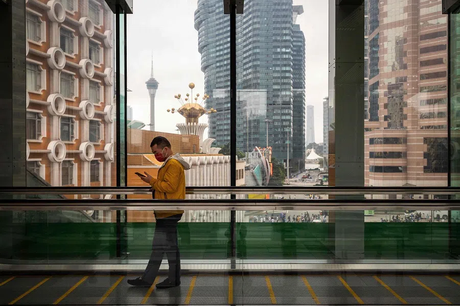 A man uses his phone on a walkway inside a hotel in Macau, China, on 3 May 2023. (Eduardo Leal/AFP)