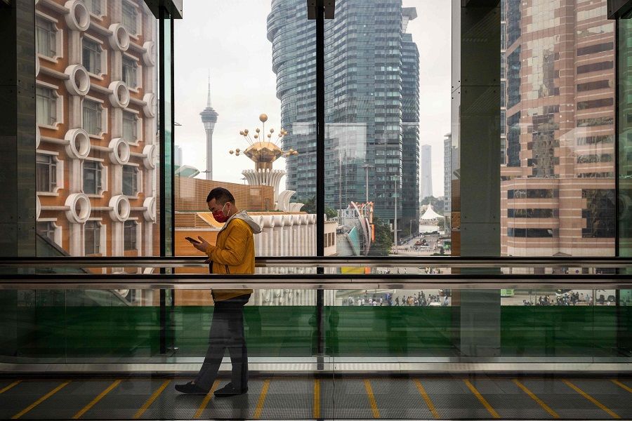 A man uses his phone on a walkway inside a hotel in Macau, China, on 3 May 2023. (Eduardo Leal/AFP)
