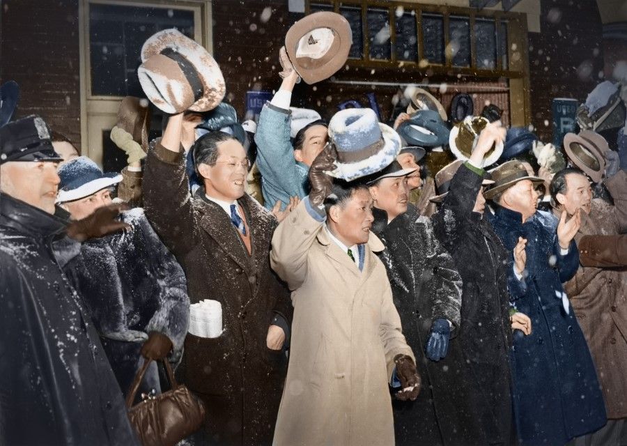 Chinese along the road wave their hats in greeting, heedless of the snow and cold, as Madame Chiang exits Carnegie Hall in New York, after a meeting with a Chinese charity association, March 1943.