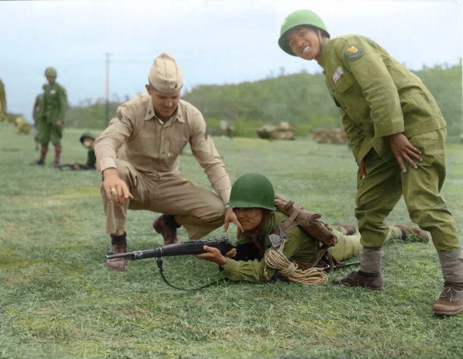 An instructor from the US army gestures as he corrects the position of a Kuomintang soldier, 1954.