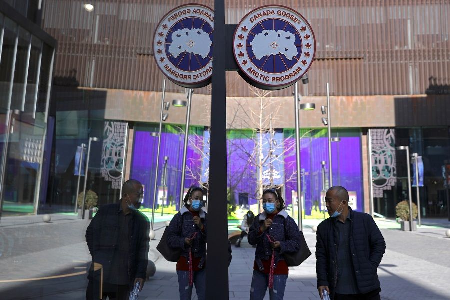 People leave a Canada Goose store in Beijing, China, 2 December 2021. (Tingshu Wang/Reuters)