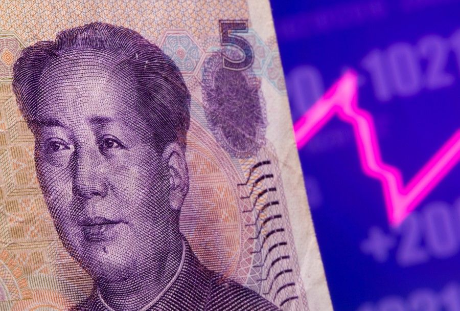 A Chinese Yuan banknote is seen in front of displayed stock graph in this illustration taken on 7 May 2021. (Dado Ruvic/Reuters)