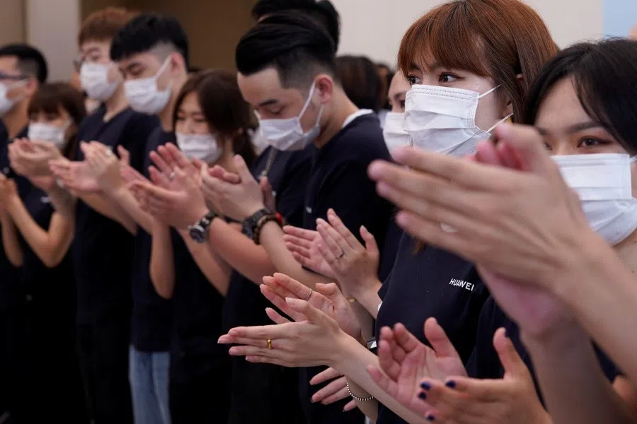 Staff members applaud as people visit Huawei's new flagship store, as it officially opens in Shanghai, 24 June 2020. (Aly Song/REUTERS)