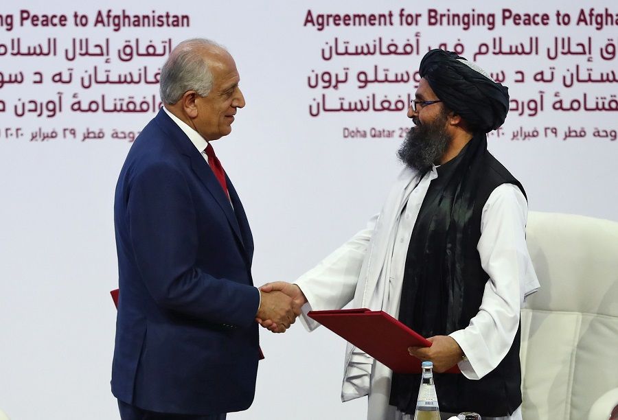 In this file photo taken on 29 February 2020, US Special Representative for Afghanistan Reconciliation Zalmay Khalilzad (right) and Taliban co-founder Mullah Abdul Ghani Baradar shake hands after signing a peace agreement during a ceremony in Doha. (Karim Jaafar/AFP)
