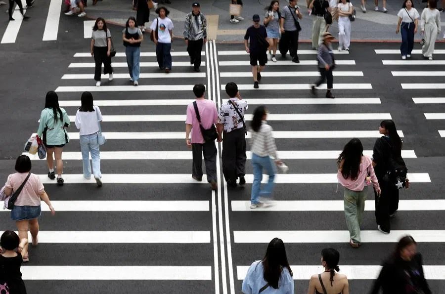 Pedestrians cross a street in Zhongshan district, Taipei, Taiwan, on 11 April 2026. (Edgar Su/Reuters)