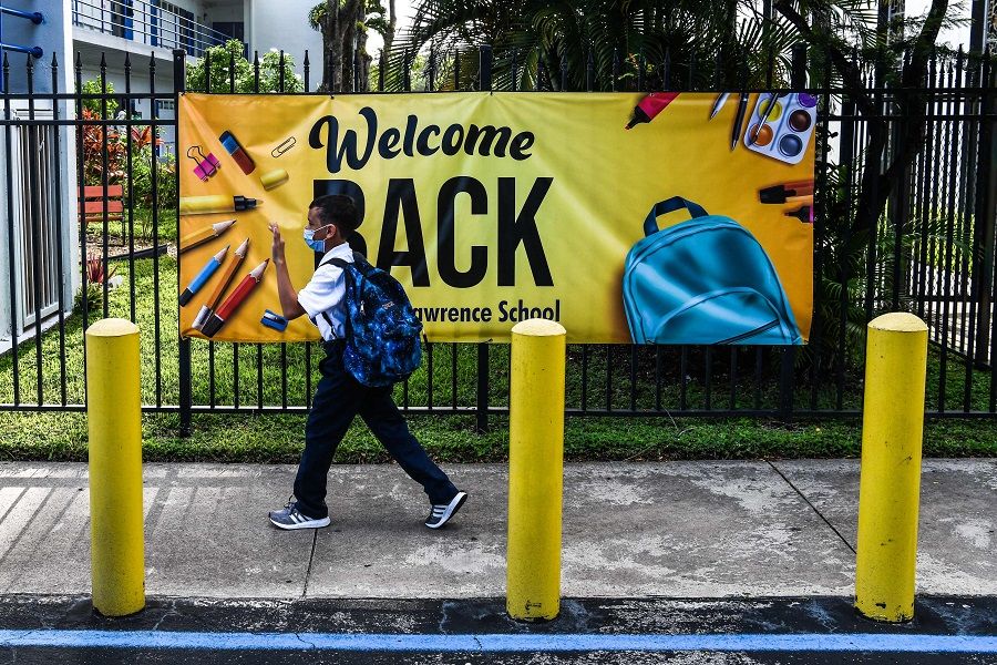 A student wears a mask as he enters the St. Lawrence Catholic School on the first day of school after summer vacation in Miami, Florida, US, on 18 August 2021. (Chandan Khanna/AFP)
