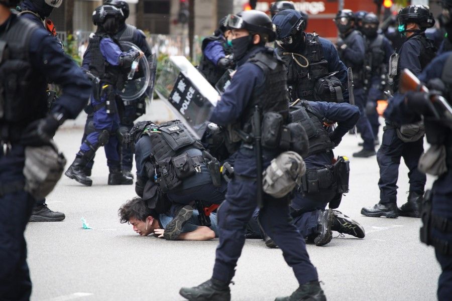 Police special tactical squad detain a protester (C) in Wanchai, Hong Kong, 24 May 2020, as thousands of demonstrators took to the streets to protest against a national security law. (Yan Zhao/AFP)