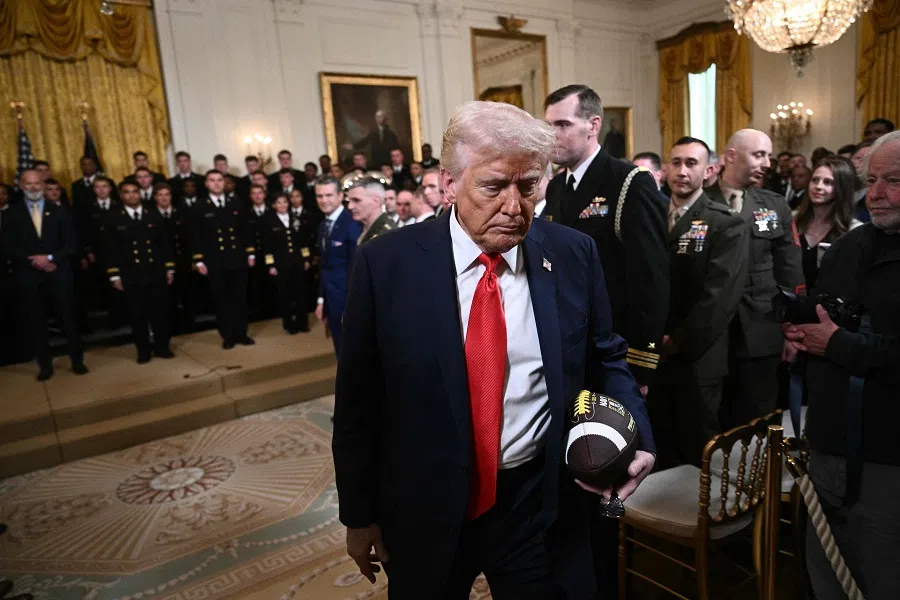 US President Donald Trump holds a football as he departs a ceremony in the East Room of the White House on 15 April 2025 in Washington, DC.