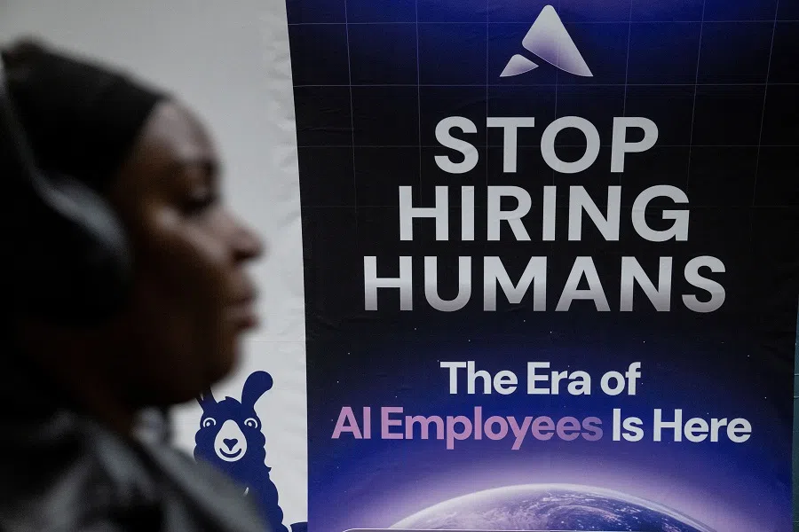 A person passes a billboard for an Artificial Intelligence company advertising AI employees on a London underground station platform in London, Britain, on 5 June 2025. (Chris J. Ratcliffe/Reuters)
