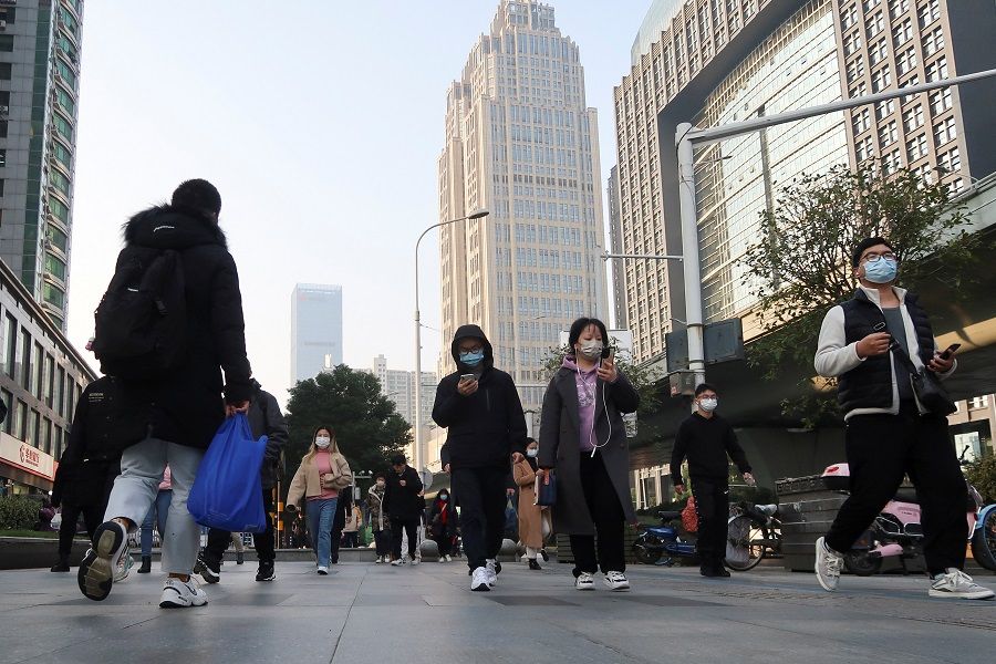 People walk on a street during morning rush hour in Wuchang district, after the government gradually loosened the restrictions on Covid-19 control, in Wuhan, Hubei province, China, 9 December 2022. (Martin Pollard/Reuters)