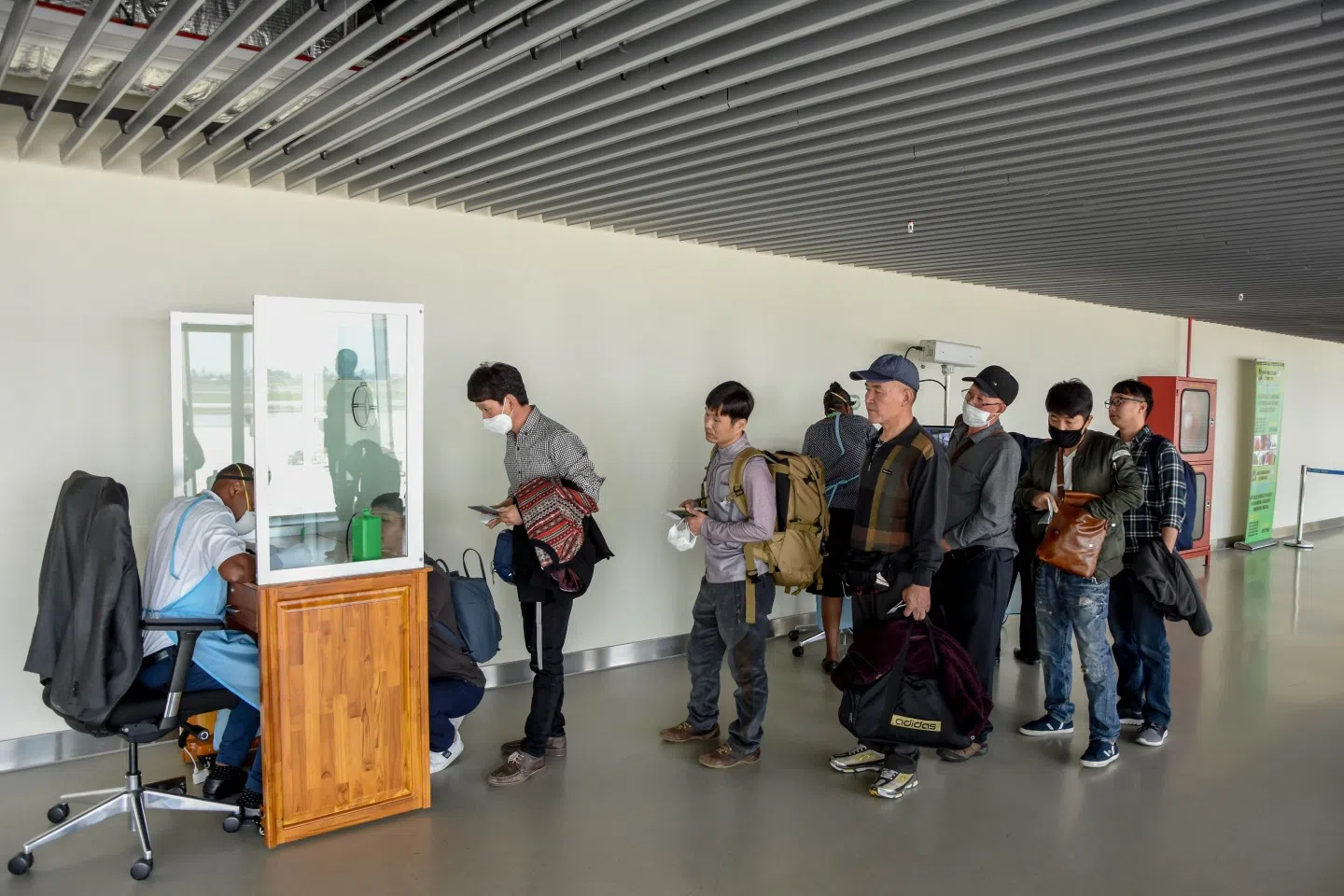 Passengers arriving from China wait in line to be checked by health officials at the Julius Nyerere International Airport in Dar Es Salaam on 29 January 2020. (Ericky Boniphace/AFP)