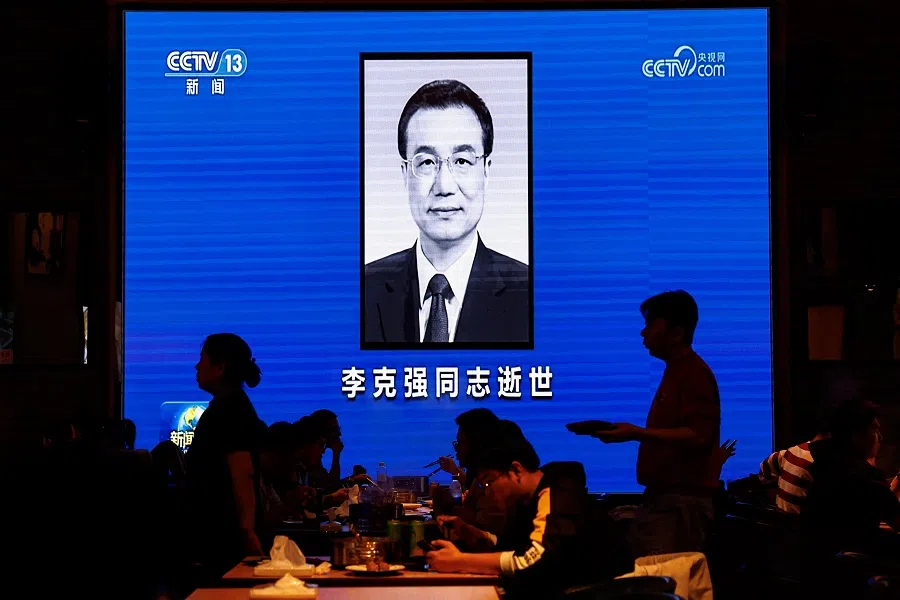 People dine near a screen broadcasting obituary of China's former Premier Li Keqiang during the evening news, following his death, at a restaurant in Beijing, China, on 27 October 2023. (Tingshu Wang/Reuters)