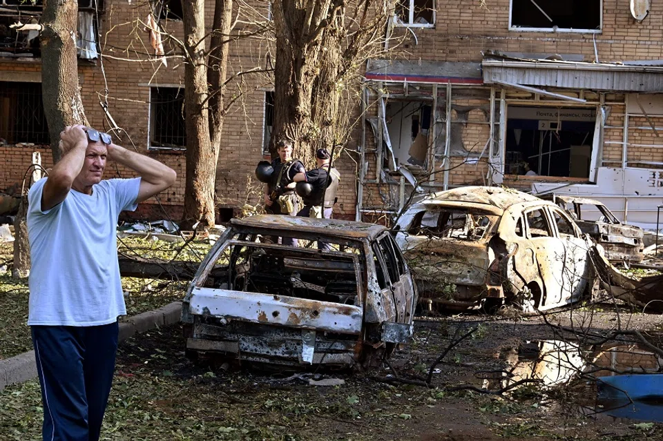 A man reacts while standing next to burnt-out remains of cars in the courtyard of a multi-storey residential building, which according to local authorities was hit by debris from a destroyed Ukrainian missile, in the course of Russia-Ukraine conflict in Kursk, Russia, on 11 August 2024. (Kommersant Photo/Anatoliy Zhdanov via Reuters)