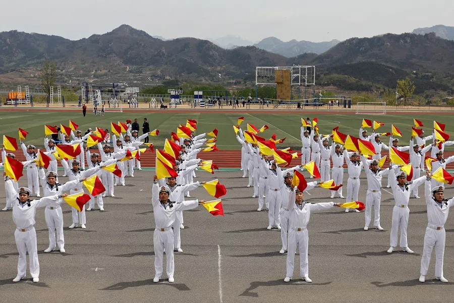 Cadets demonstrate flag signals during a media tour to an open day at the PLA Naval Submarine Academy, ahead of the 75th founding anniversary of the PLAN, in Qingdao, Shandong province, China, 21 April 2024. (Florence Lo/Reuters)