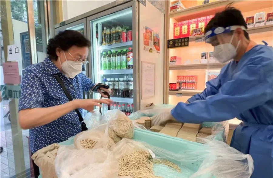 An elderly lady buys noodles at a branch of No. 6 Oil and Grain. (Internet)
