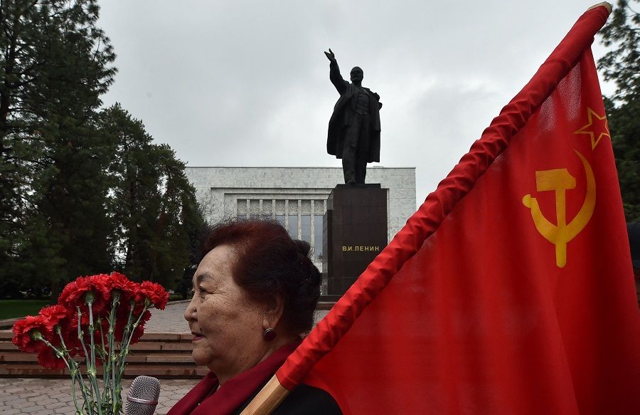A woman holds a flag of the USSR during a gathering of Kyrgyz communist supporters to pay their respects to Soviet Union founder and revolutionary leader Vladimir Lenin during a rally marking the 151st anniversary of Lenin's birth, in central Bishkek, Kyrgyzstan, on 22 April 2021. (Vyacheslav Oseledko/AFP)