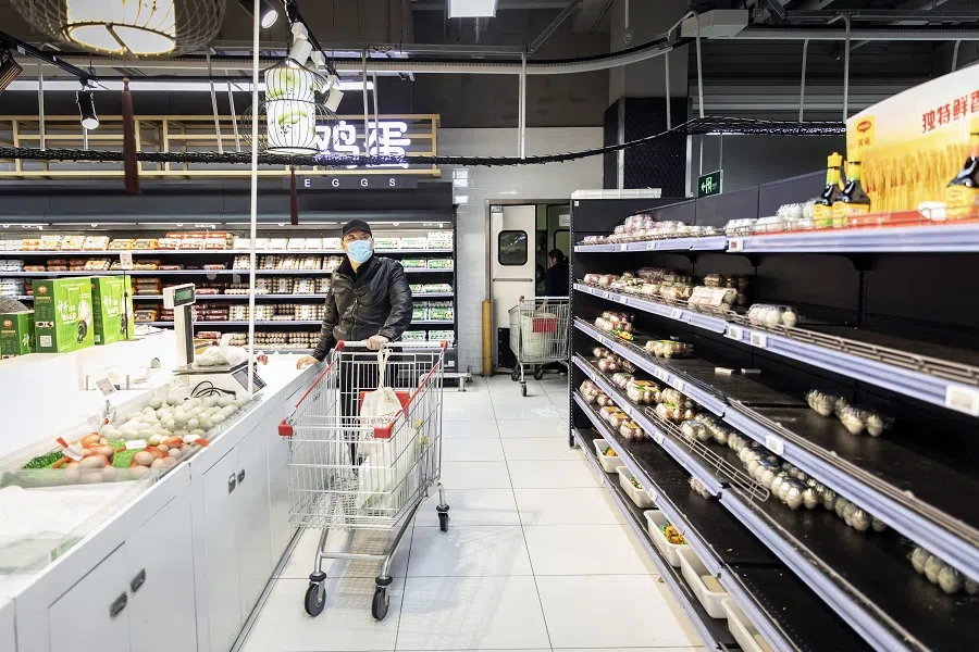 A customer next to near-empty shelves at a supermarket ahead of a phased lockdown due to Covid-19 in Shanghai, China, on 31 March 2022. (Qilai Shen/Bloomberg)