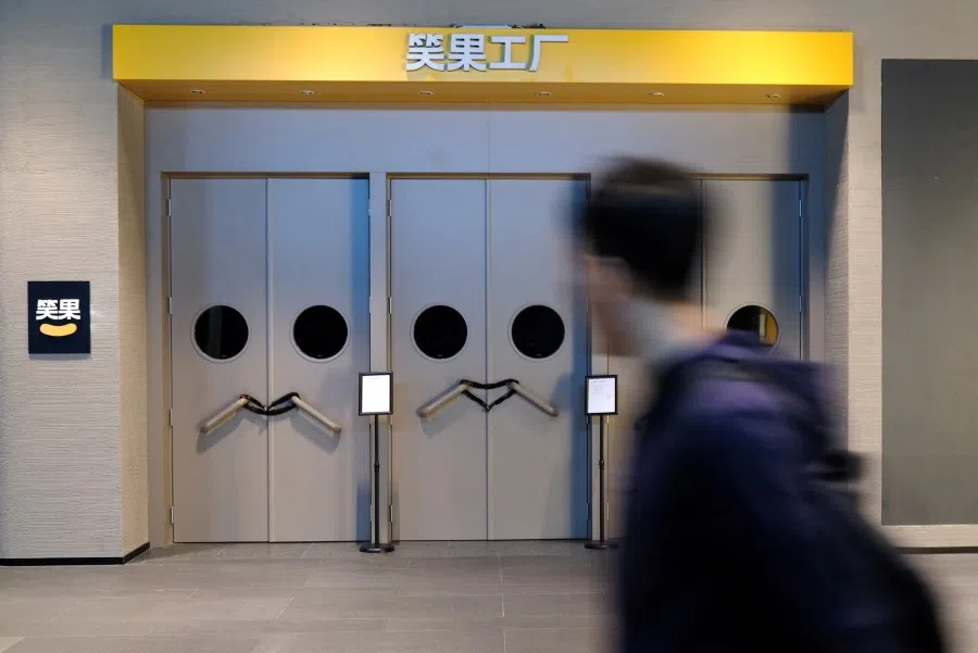 A person walks past a show venue of stand-up comedy company Xiaoguo Culture Media Co that has closed its business with a notice of show cancellation, in Beijing, China, 19 May 2023. (Tingshu Wang/Reuters)