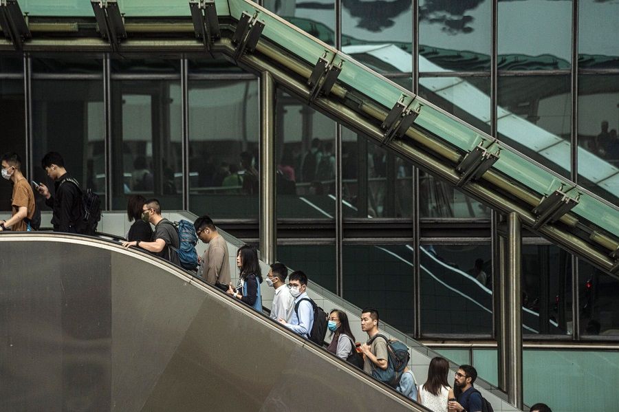 Pedestrians ride an escalator in Hong Kong, China, on 24 April 2023. (Lam Yik/Bloomberg)