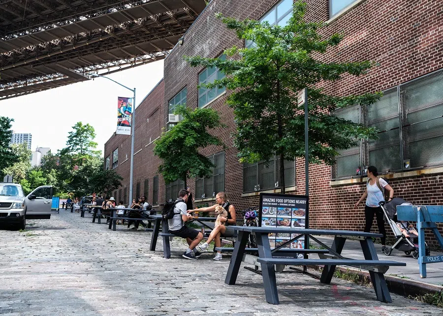 People dine al fresco underneath the Brooklyn Bridge on Dock Street between Front and Water Streets on 4 July 2020 in the Brooklyn borough of New York City. (Byron Smith/Getty Images/AFP)