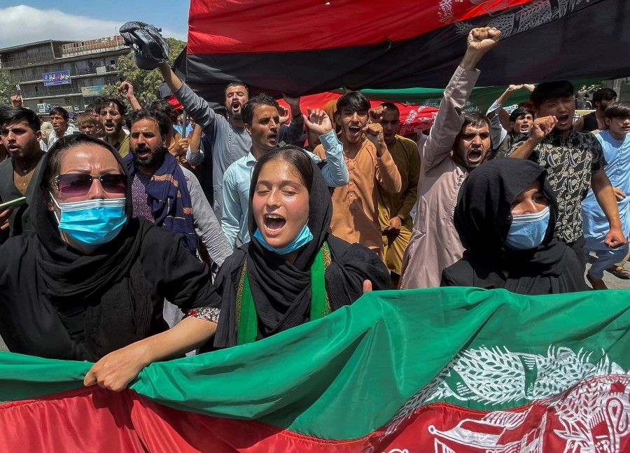 People carry the national flag at a protest held during the Afghan Independence Day in Kabul, Afghanistan, 19 August 2021. (Stringer/Reuters)