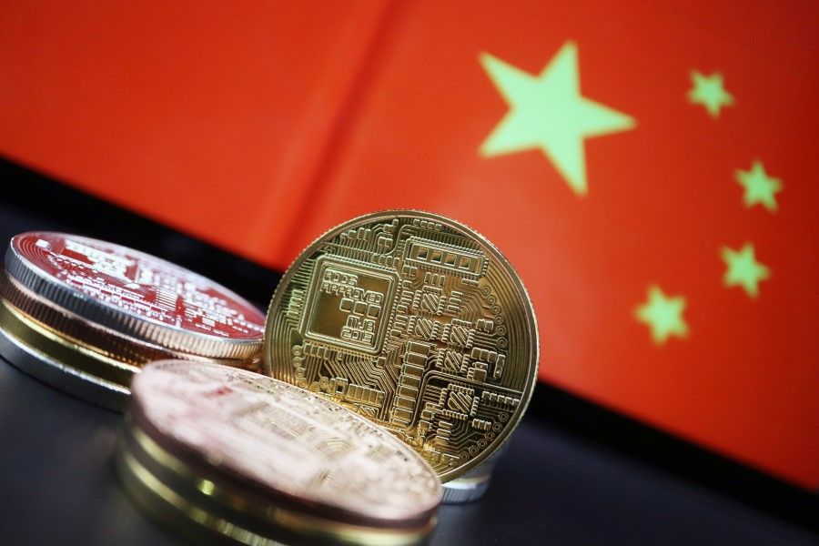 Cryptocurrency representations are seen in front of an image of the Chinese flag in this illustration picture taken 2 June 2021. (Florence Lo/Reuters)